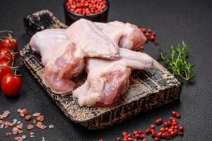 Fresh raw chicken wings with salt and spices prepared for baking photo