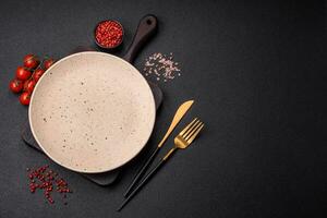 Empty round ceramic plate on a dark textured background photo