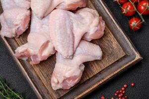 Fresh raw chicken wings with salt and spices prepared for baking photo