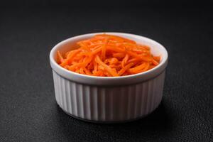 Delicious spicy carrots sliced and cooked in Korean style on a ceramic plate photo