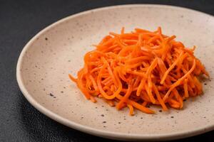 delicioso picante zanahorias rebanado y cocido en coreano estilo en un cerámico plato foto