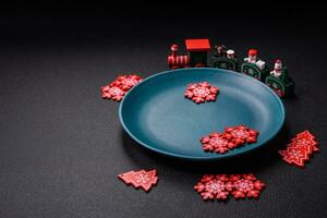 Ceramic round plate decorated with festive elements on the Christmas table photo