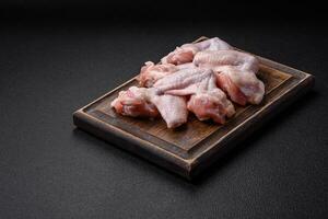 Fresh raw chicken wings with salt and spices prepared for baking photo