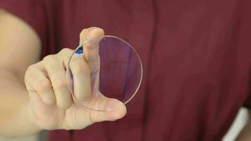 detailopname van hand- Holding lens bril Aan vervagen achtergrond, lens bril video