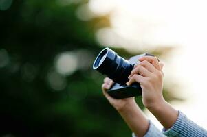 Take pictures with a mirrorless camera. Little girl practicing nature photography little photographer the joy of taking pictures photo