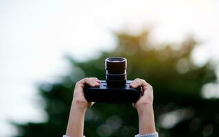 Take pictures with a mirrorless camera. Little girl practicing nature photography little photographer the joy of taking pictures photo