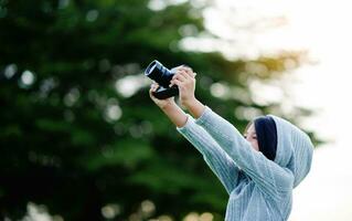 Take pictures with a mirrorless camera. Little girl practicing nature photography little photographer the joy of taking pictures photo