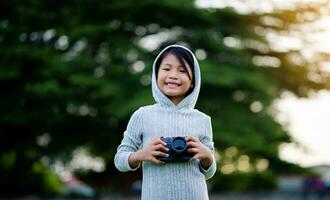 Take pictures with a mirrorless camera. Little girl practicing nature photography little photographer the joy of taking pictures photo