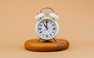 Modern alarm clock placed on a wooden plan Time clock, notifications, alarms time and work concept photo