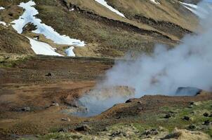 Snow on the Mountains Around a Geothermal Valley photo