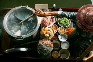 thai noodle food making on floating boat in floating market thailand photo