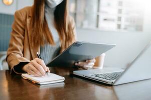 businesswoman hand working with new modern computer and writing on the notepad strategy diagram as concept photo