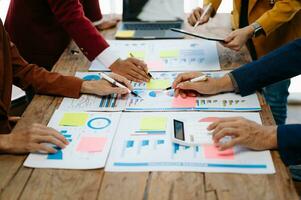 Businessman and team analyzing financial statement Finance task. with smart phone and laptop and  tablet. Wealth management concept photo