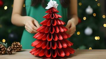 Red Paper Christmas Tree with White Flower and Pine Cones on Wooden Table photo