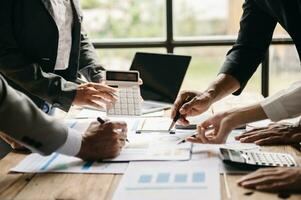 Business documents on office table with smart phone and calculator digital tablet and graph business with social network diagram and two colleagues discussing data working in the office photo