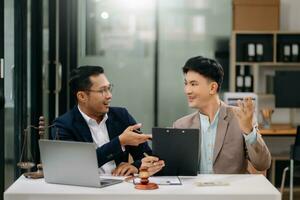 Two lawyers are discussing about contract paper, law matters determination, pointing.law and hammer on the table photo