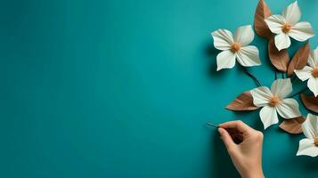 Hand Painting White Flowers with Brown Leaves on a Teal Background photo