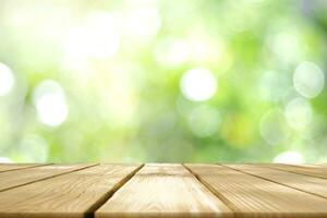 Empty wooden table with Blurred image of abstract circular green bokeh from nature style background. photo