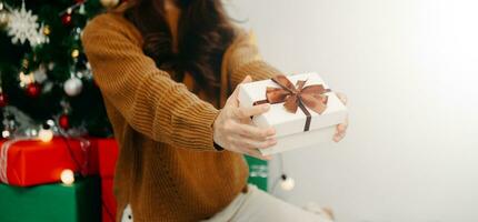 Woman's hands hold christmas or new year decorated gift box. Merry Christmas photo