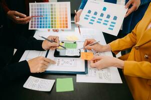 UX developer and ui designer brainstorming about mobile app interface wireframe design with customer breif and color code at modern office. photo