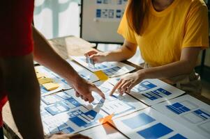 UX developer and ui designer brainstorming about mobile app interface wireframe design with customer breif and color code at modern office. photo