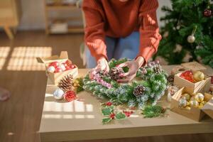 mujer haciendo muérdago guirnalda Navidad guirnalda decoración con mano hecho bricolaje invierno verdor florista manos haciendo Navidad guirnalda hermosa muérdago. foto