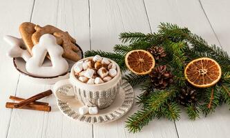 hermosa de punto modelo taza con caliente cacao y malvavisco, hecho a mano pan de jengibre plato en blanco de madera mesa. Navidad tradicional beber. foto