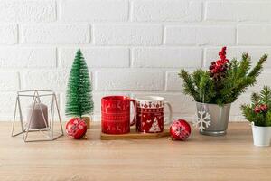 a fragment of a white wooden countertop with various kitchen utensils and Christmas decorations. candles, balls, branches of spruce. photo