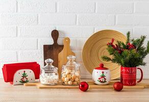 Modern home kitchen interior concept. Spruce branches, wooden cutting boards, dishes with a New Year's pattern. Front view of the kitchen countertop. photo