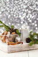 Metal white basket with glazed gingerbread, nuts on wooden white podium with lantern. New Year winter concept. Vertical background. bokeh. photo
