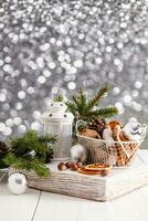nuevo año y Navidad composición con un blanco linterna, un cesta con pan de jengibre y seco naranja rebanadas abeto sucursales. , Bokeh. vertical vista. foto