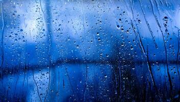 Drops of rain on blue glass background photo