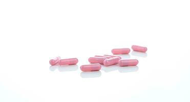 Pink capsule pills on white background. Pharmaceutical industry. Vitamins, minerals, and supplements concept. Pharmacy products. Pharmaceutical medicine. Prescription drugs. Healthcare and medicine. photo