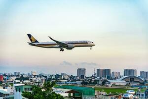 Ho chi minh, Vietnam - 7 7 agosto 2023 aerolíneas mosca pasado punto de referencia 81, el más alto edificio en Vietnam, a tierra a bronceado hijo nhat internacional aeropuerto. foto