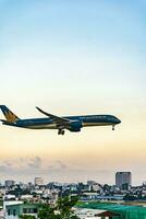 Ho Chi Minh, Vietnam - 7 August 2023 Airlines fly past landmark 81, the tallest building in Vietnam, to land at Tan Son Nhat international airport. photo