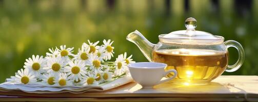 Chamomile flowers, books, a glass teapot, and a cup of herbal tea on a table closeup. Generative AI photo