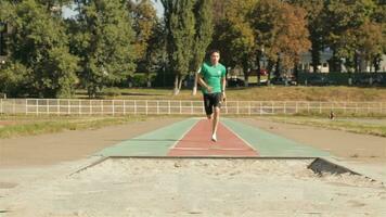 männlich Sportler Praktiken Methoden Ausübungen lange Springen beim das Stadion video