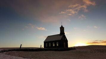 Hvalsneskirkja church located near the village of Sandgerdi in Iceland in winter at sunset. photo