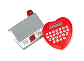 Calculator heart shaped and miniature house. photo