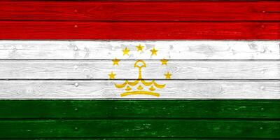 bandera de república de Tayikistán en un texturizado antecedentes. concepto collage. foto