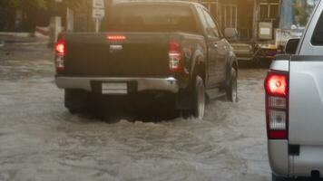 Rear side view of pickup car silver color on flooded area. With other car on the road can see only water from flood by heavy rain. photo