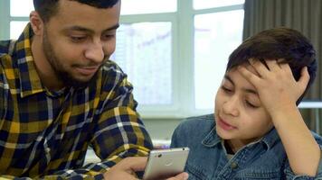 Father and son looking at smartphone video