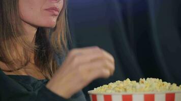 Woman takes flakes of popcorn from the bucket video