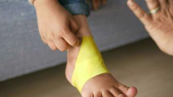 elastisch therapeutisch Blau Band angewendet zu Kind Bein. Kinesio Taping Therapie zum Verletzung video
