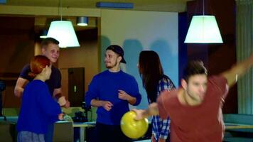 People raise their hands at the bowling video