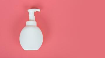 Cosmetic mock up bottle on pastel pink background photo