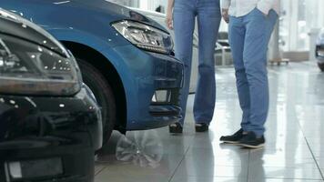 Couple stands near the blue car video