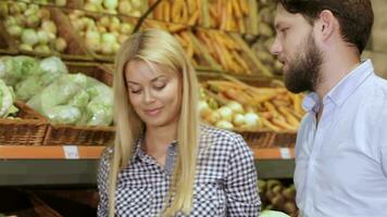 Pareja compras a el vegetal sección de supermercado video