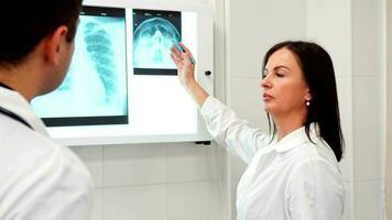 Female doctor points pencil on the x-ray of human head video