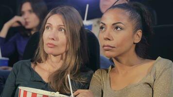 Two women looking at the screen at the movie theater video